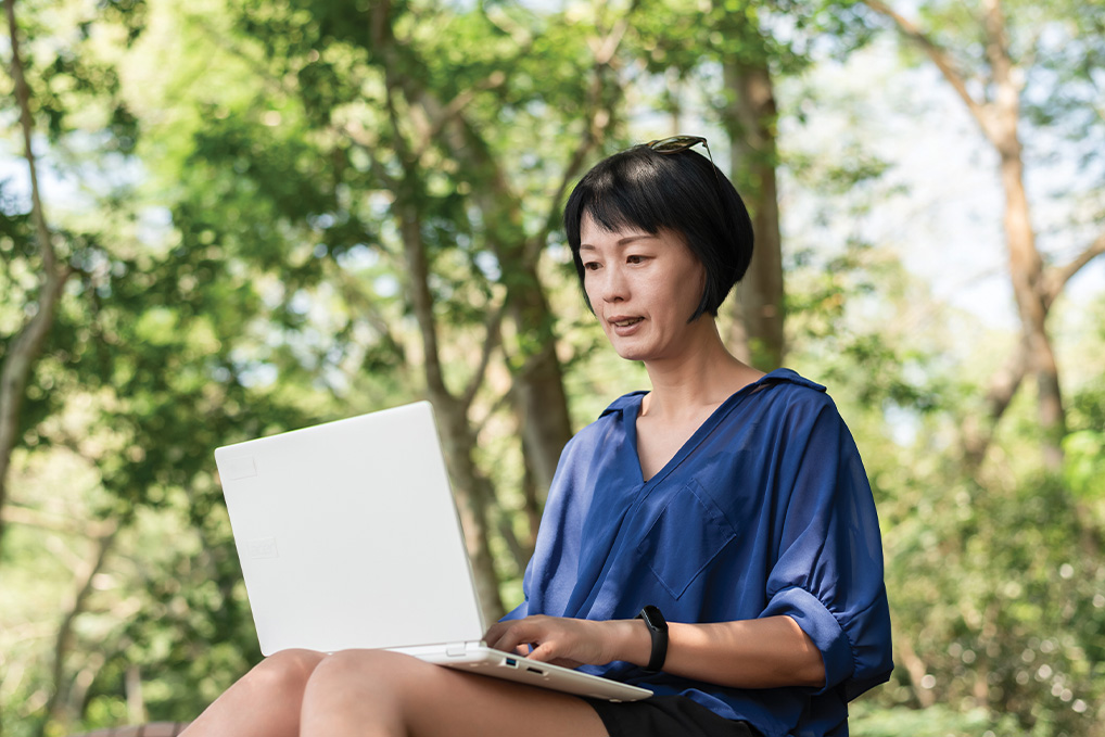 woman outside looking at laptop