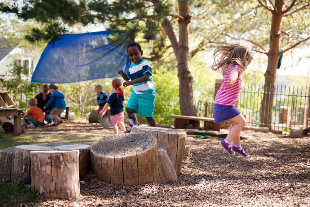 children jumping off of logs